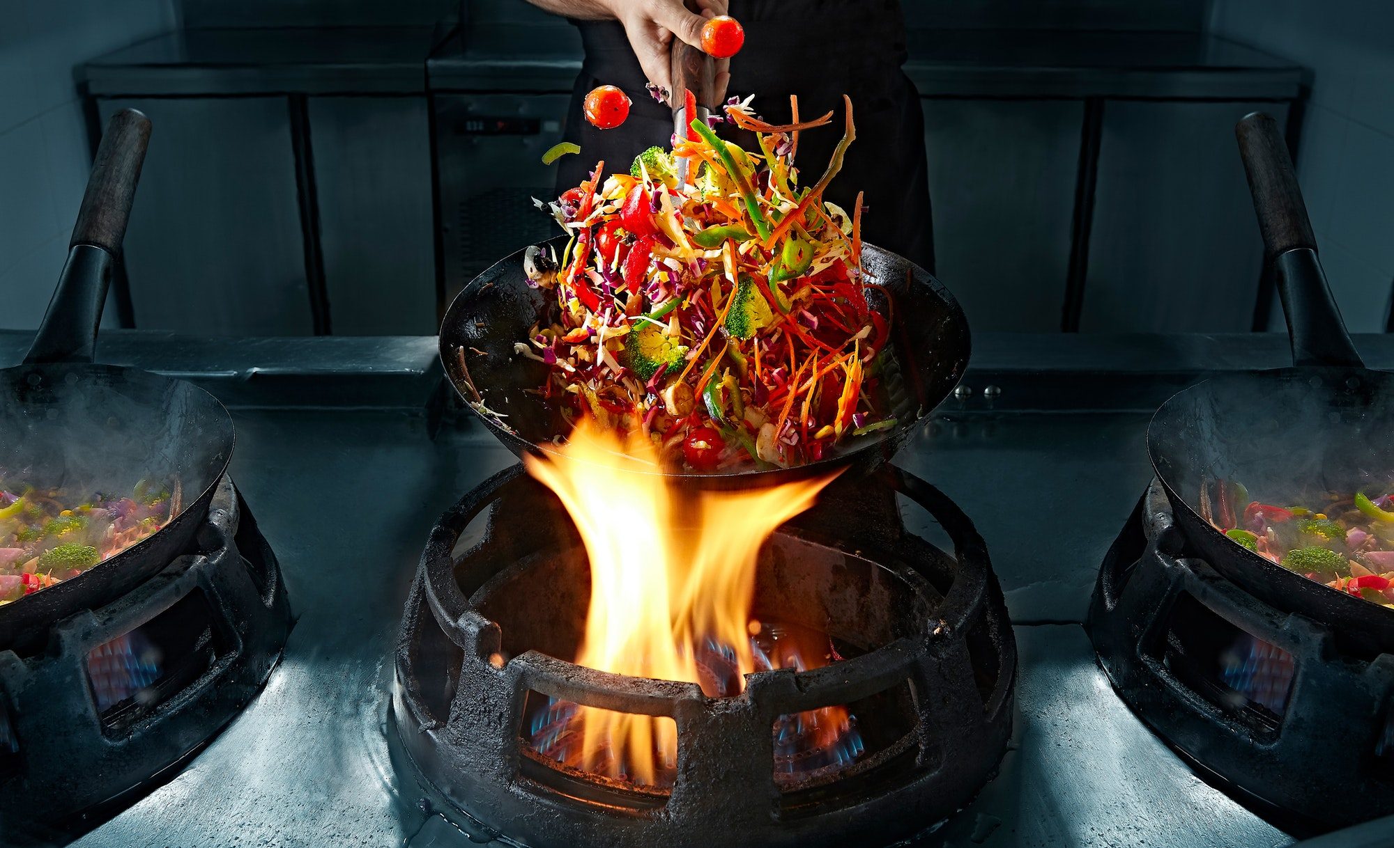 crop hand cooking vegetable wok on pan